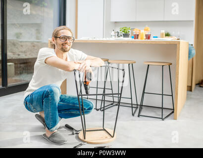 Man assembling chair in the apartment Stock Photo