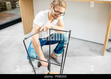 Man assembling chair in the apartment Stock Photo