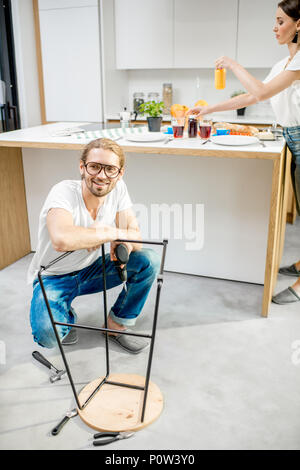 Man assembling chair in the apartment Stock Photo