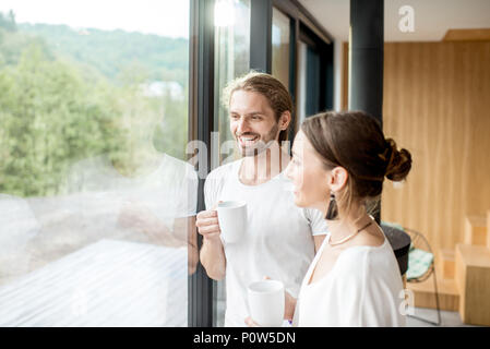 Couple standing near the window indoors