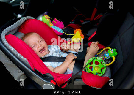 Little child, baby boy crying in the car, in car seat, child not wanting to travel Stock Photo
