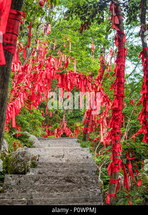 Red ribbon with written wishes hangging on the trees at Tianmen Mountain, The Heaven's Gate at Zhangjiagie, Hunan Province, China, Asia Stock Photo