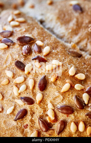 Close up picture of a whole wheat bread crust with flax and sesame seeds, selective focus. Stock Photo