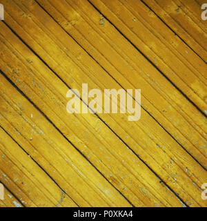 Abandoned place decoration. Dry yellow paint on the wooden surface. Peeling. Cracked texture. Scratched background. Toned photo. An old colorful wall. Stock Photo
