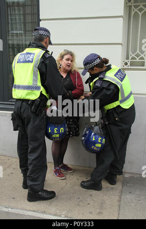 London, UK - 10 June 2018: A woman is searched and questioned by police officers during the demonstration outside the Saudi Arabia Embassy for Al Quds Day on 10 June 2018. The annual event held on the last Friday of Ramadan that was initiated in 1979 to express support for the Palestinians and oppose Zionism and Israel. Credit: David Mbiyu Stock Photo