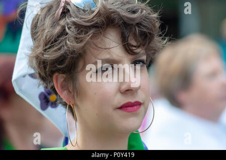 Edinburgh, Scotland, UK. 10th June, 2018. A woman with large hooped earrings during the Edinburgh Processions Artwork march celebrating 100 years since British women won the right to vote. Thousands of women came together in the four capitals of the UK,  Belfast, Cardiff, Edinburgh and London. The Participants wore either a green, white or violet scarf and walked in stripes through the city streets to depict the colours of the suffragettes. Credit: Skully/Alamy Live News Stock Photo