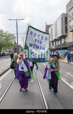 Edinburgh, Scotland, UK. 10th June, 2018. Marchers carrying a banner that says Votes For Women during the Edinburgh Processions Artwork march celebrating 100 years since British women won the right to vote. Thousands of women came together in the four capitals of the UK,  Belfast, Cardiff, Edinburgh and London. The Participants wore either a green, white or violet scarf and walked in stripes through the city streets to depict the colours of the suffragettes. Credit: Skully/Alamy Live News Stock Photo