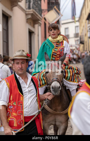 Orotava, Tenerife, Canary Islands, June 10, 2018: Thousands of people in Canaries regional costumes take the streets at a festival and a Pilgrimage to celebrate country traditions in La Orotava, Tenerife, Canary Islands, in honour of San Isidro Labrador and Santa Maria de la Cabeza, patrons of the area. They dance, sing, and give away food or drinks to those attending the event, spectator or active participant. Stock Photo