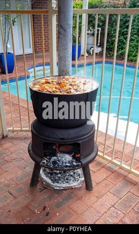 Hungarian beef goulash cooked in a large cast iron pot, ingredients paprika, beef, carrots, and potatoes. Stock Photo