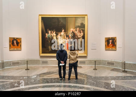 Goya painting Prado, rear view of a young couple visiting the Prado Museum in Madrid looking at The Family of Carlos IV by Francisco Goya, Spain. Stock Photo