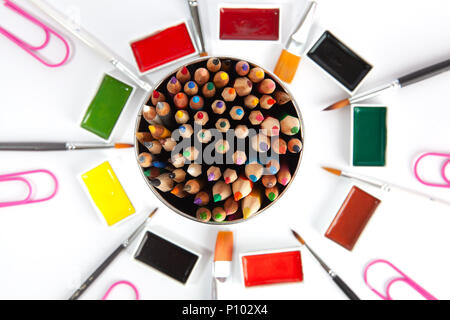 Colored pencils top view with blurred art supplies in the background - image with shallow depth of field Stock Photo
