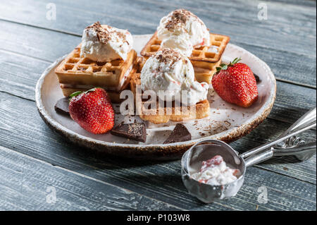 Belgian Wafers with vanilla ice cream, fresh strawberries and chocolate. Delicious breakfast. Stock Photo