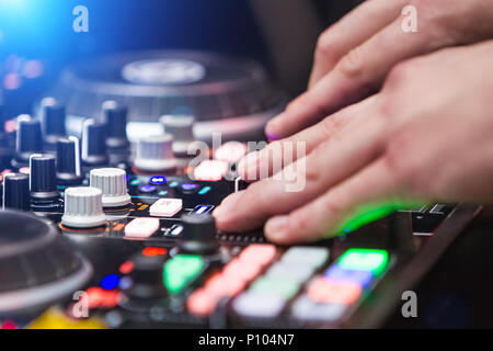 close up hands of DJ playing music at mixer Stock Photo