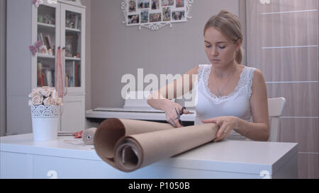 Young woman cutting wrapping paper Stock Photo