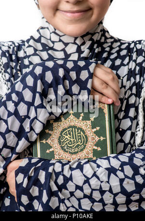 Young Muslim Girl Hugging Holy Book of Quran Stock Photo