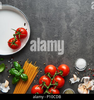 Food background for tasty Italian dishes with tomato. Various cooking ingredients with spaghetti. Top view, square crop with copy space. Stock Photo