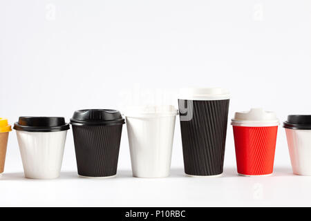 Endless row of disposable coffe cups of different colors and sizes on white background with copy space Stock Photo