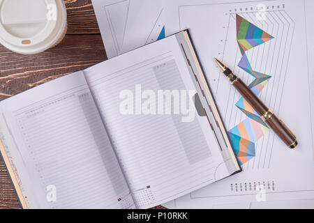 Paperwork concept, top view. Notepad, pen and disposable cup of coffee. Stock Photo