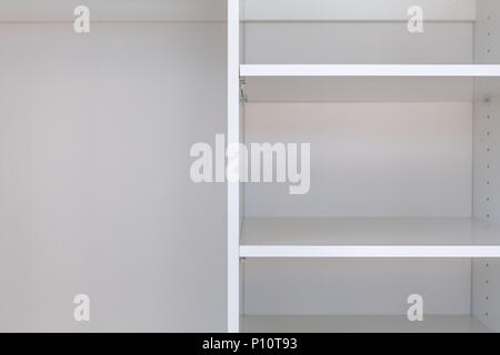 Close-up of empty shelves in white cupboard Stock Photo
