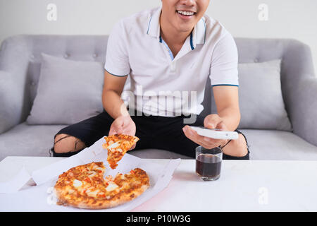 Man eating pizza having a takeaway at home relaxing resting Stock Photo