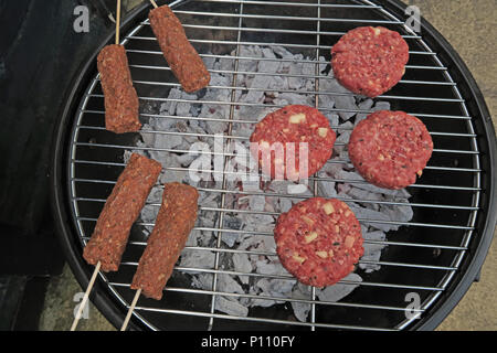 Dangers of food poisoning from summer BBQ meat,Sausages,beef burgers, Kebabs, under-cooked or raw. highlighting food safety dangers during summer BBQs Stock Photo
