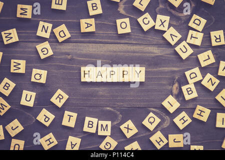 Happy word wood block on table for business concept. Stock Photo