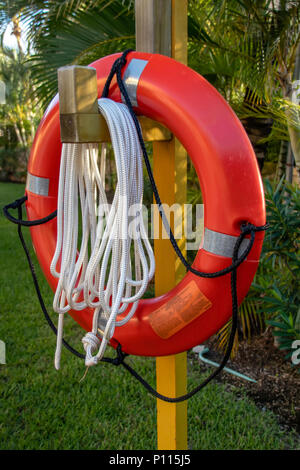 Red Lifebuoy hanging on a pillar Stock Photo