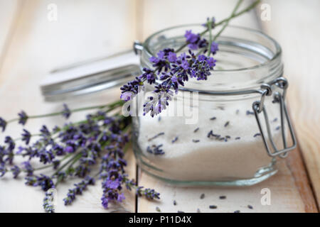 bouquet of fresh lavender and sugar in a glass jar on a light wooden background closeup Stock Photo
