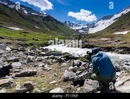 male landscape photographer working on location on a shoot in the Swiss Alps near Klosters Stock Photo