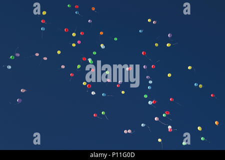 Multiple colourful balloons rising up to the dark blue sky Stock Photo ...