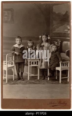 HODONIN, AUSTRIA-HUNGARY - CIRCA 1910: Vintage cabin card shows a group of children. Antique black white photo was taken in studio. Stock Photo