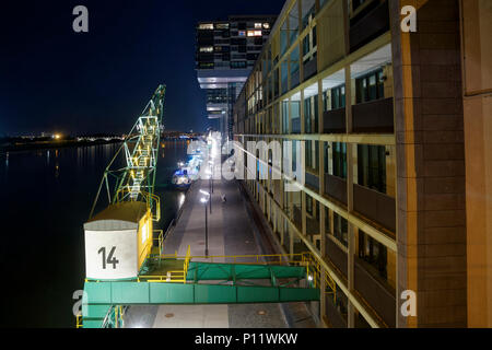 The former river habour in Colgone at night with a crane and cargo ships. Nowadays it is an urban regeneration project with modern apartments. Stock Photo