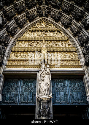 Showing the Madonna and the child is one of the most popular images of Mary in the Middle Ages. Here is Mary as Queen of Heaven. The statue was sculptured at 1880. Above the statue is a tympanum, which shows scenes of the Old and New Testament (rom the top down): the Fall of Man; Noah’s ark, Moses receiving the Tablets of the Law, and the Worship of the Golden Calf; the Annunciation, the Nativity, and the Presentation of the Christ Child in the Temple; Christ among the Doctors, the Baptism of Christ, and the Sermon on the Mount. The seated figures in the archivolts are characters from the Old  Stock Photo