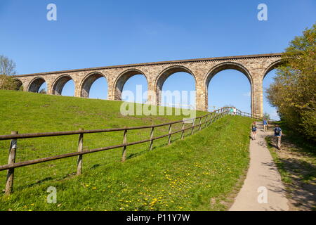 People walking towards the railway viaduct in Cefn Mawr Country Park Stock Photo