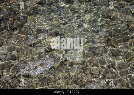 Through the crystal clear water we can see rocks of different colours inside. Every major rock classification can be found on or under the sea bottom. Stock Photo
