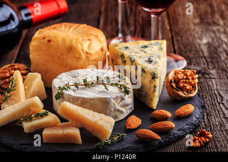 Cheese, nuts, honey and red wine on wooden background, selective focus. Stock Photo
