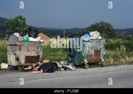 Overfilled trash and garbage bags with food waste on the street Stock Photo