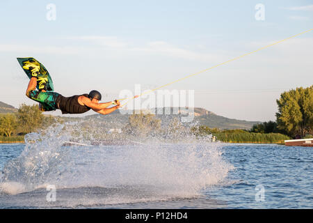 PASOHLAVKY, CZECH REPUBLIC - JUNE 03, 2017: Rider jumping in the cable wake park Merkur in South Moravia, with Palava mountains in the background Stock Photo