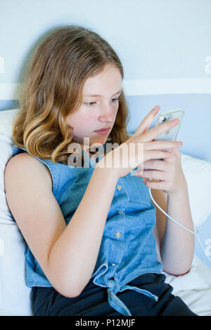 Twelve year old girl using iPhone cell phone Stock Photo