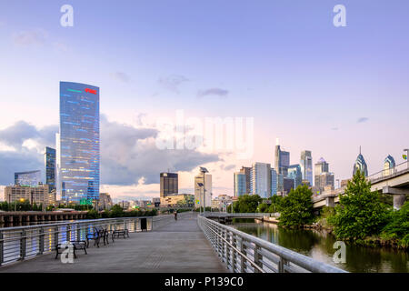 Philadelphia Skyline and Schuylkill River Park Boardwalk with Cyclist at sunset, Philadelphia , Pennsylvania, USA Stock Photo