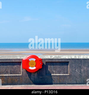 Life saving equipment attached to seawall on Blackpool seafront at low tide in summer Stock Photo