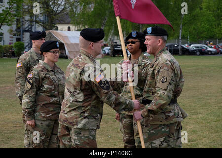 KAISERSLAUTERN, Germany — Left, Army Reserve Col. Daniel F. Bohmer, commander, Medical Support Unit – Europe, 7th Mission Support Command receives the MSU-E unit colors from Army Reserve Brig. Gen. Steven W. Ainsworth, the 7th MSC commanding general, right, as Army Reserve Col. Bidemi Y. Olaniyi-Leyimu, former commander, MSU-E, 7th MSC, center, looks on, during an outdoor change of command ceremony on Daenner Kaserne, May 6, 2017.   The MSU-E is an Army Reserve unit under the command of the 7th MSC, which has Soldiers with 29 medical specialties plus administrative professionals. Stock Photo