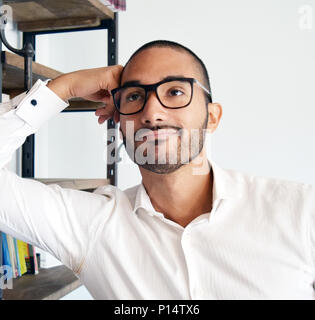 Handsome latino man with glasses thinking at office Stock Photo