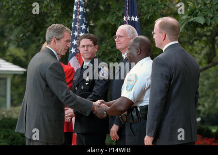 President George W. Bush shakes hands with a police officer Tuesday, Sept. 18, 2001, in the Rose Garden of the White House after thanking charitable organizations for their relief efforts at the World Trade Center and Pentagon and announcing the creation of the American Liberty Partnership. Stock Photo