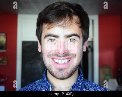 Portrait headshot of a handsome man smiling indoors Stock Photo