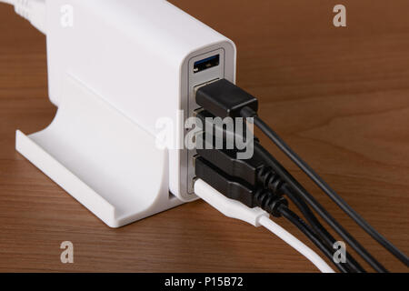 multiport charging station and charging cables on a wooden background Stock Photo