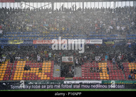 A heavy rain prior to the match. Former captain of the Czech national football team Tomas Rosicky definitely ended his career at the age of 37 in a farewell match played despite a driving cloudburst which postponed its kickoff today, on Saturday, June 9, 2018. The Czech team, in which he played, defeated the 'team of the world,' composed of his former fellow players from Borussia Dortmund and Arsenal London, 5-2. The final goal was scored by Rosicky's four-year-old son Tomas. Weather complicated the farewell match as roughly 20 minutes before its start a driving rain forced out both the player Stock Photo