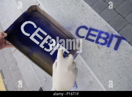 Hannover, Germany. 11th June, 2018. An employee sprays the 'Cebit' logo at the digital fair 'Cebit'. Cebit is attempting a new 'festival' format after three decades, taking place between the 11th and the 15th of June. Photo: Julian Stratenschulte/dpa Credit: dpa picture alliance/Alamy Live News Stock Photo