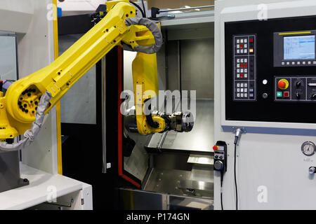CNC lathe machine and robot used for automation of loading and unloading operations. Selective focus. Stock Photo