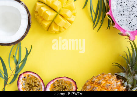 Tropical fruits mango, pitayam coconut and passion fruit on yellow background. Frame of resh fruits. Healthy lifestyle and summer concept Stock Photo